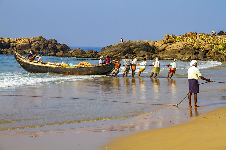 Fishermen landing their catch on Kovalam beach, Kerala