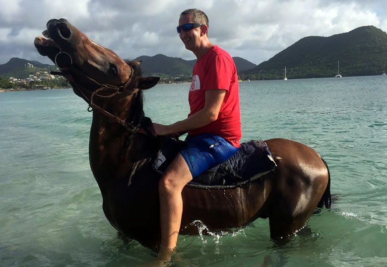 Colin Carter on a horse swimming in the Caribbean Sea