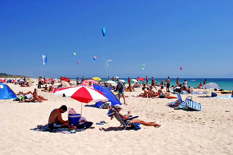 Colourful kites flying high above the beach in Tarifa